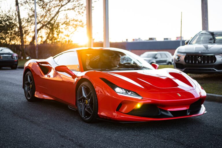 Red Ferrari supercar parked in a lot at sunset