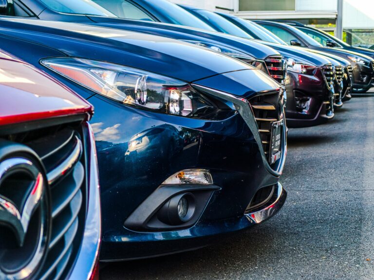 Row of sedans parked side by side in a lot