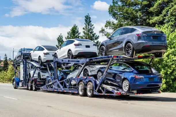 Open auto transport carrier hauling vehicles in Florida